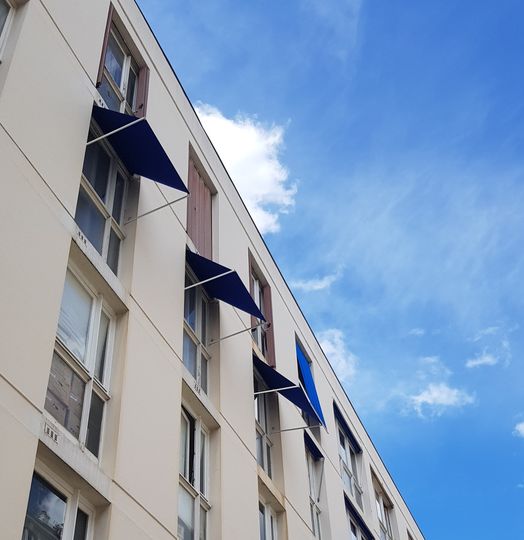 Store à projection avec armature coloris blanc, toile acrylique coloris bleu, manoeuvre manuelle par cordon pour habiller une ou plusieurs fenêtres